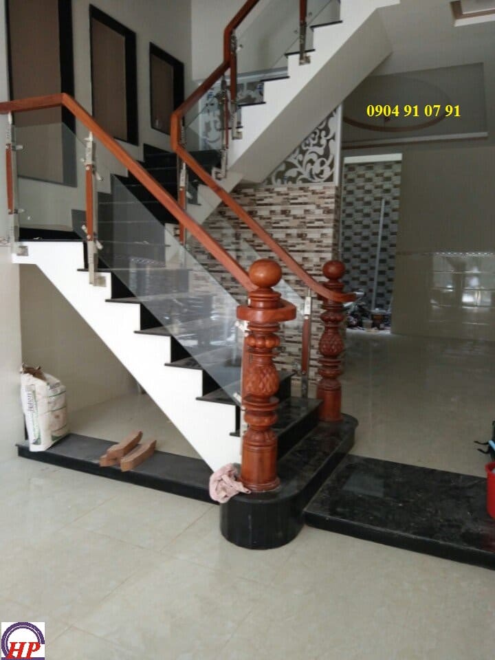Trụ inox kẹp gỗ thi công cầu thang kính